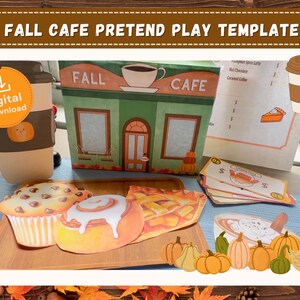 Puede incluir: Una plantilla de juego de simulación Fall Cafe con una estructura de café de papel, un menú, dinero de juguete y recortes de papel de un muffin, un rollo de canela, un pastel y calabazas. El texto dice Fall Cafe Pretend Play Template.