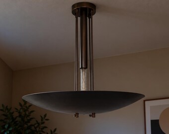 May include: A ceiling-mounted pendant light fixture featuring a wide, shallow, matte black bowl-shaped shade suspended by thin, dark metallic rods from a cylindrical central column attached to a circular ceiling canopy.