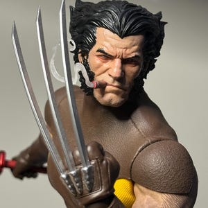 May include: A detailed action figure of Wolverine, in a brown and yellow costume, with silver claws extended. The figure has a stern expression, a cigar in his mouth, and detailed facial features.