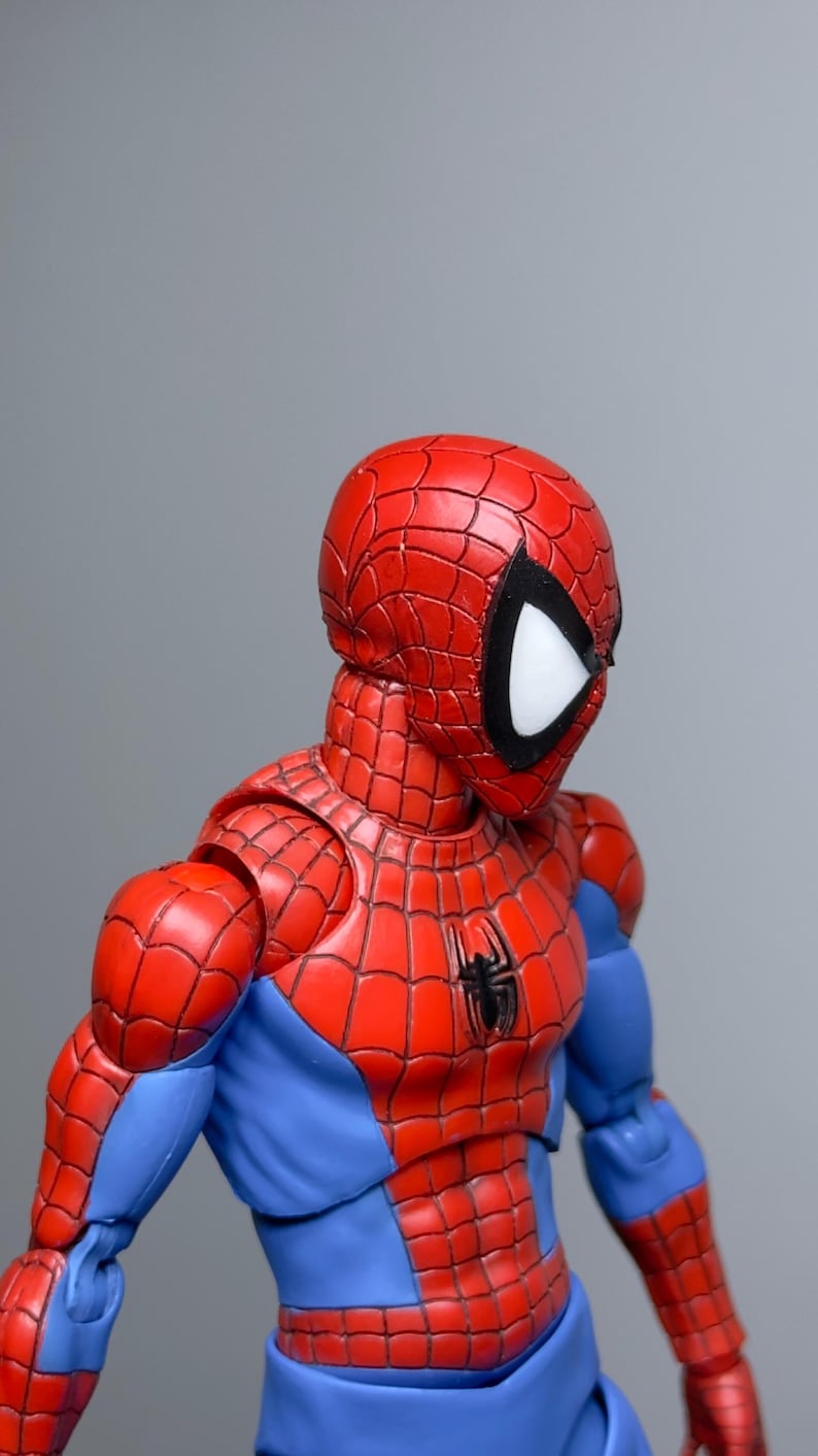 Puede incluir: Figura de acci&oacute;n detallada de Spider-Man, con un traje rojo y azul y un emblema de ara&ntilde;a en el pecho. La figura tiene una m&aacute;scara roja con lentes oculares blancas y contornos negros. El traje est&aacute; intrincadamente dise&ntilde;ado con patrones de telara&ntilde;a.