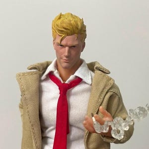 May include: A collectible action figure featuring a character with short blonde hair, wearing a white collared shirt, a bright red necktie, and a tan trench coat. The figure holds a small, translucent, cloud-like plastic effect piece in one hand.
