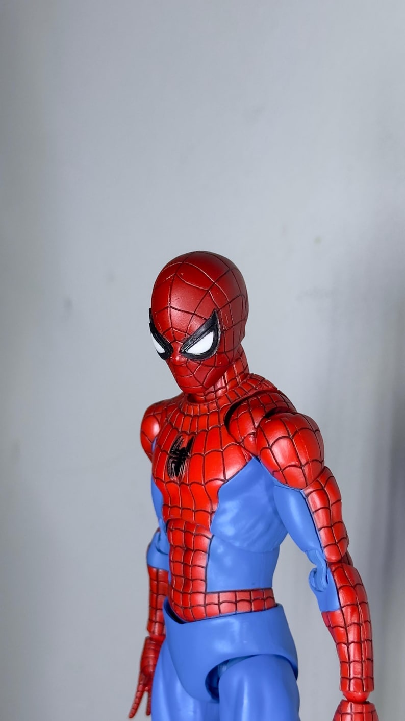 Puede incluir: Figura de acci&oacute;n de Spider-Man rojo y azul. La figura est&aacute; en una pose din&aacute;mica, con una m&aacute;scara roja y un emblema de ara&ntilde;a negra en el pecho. El disfraz de la figura presenta un patr&oacute;n de telara&ntilde;a.