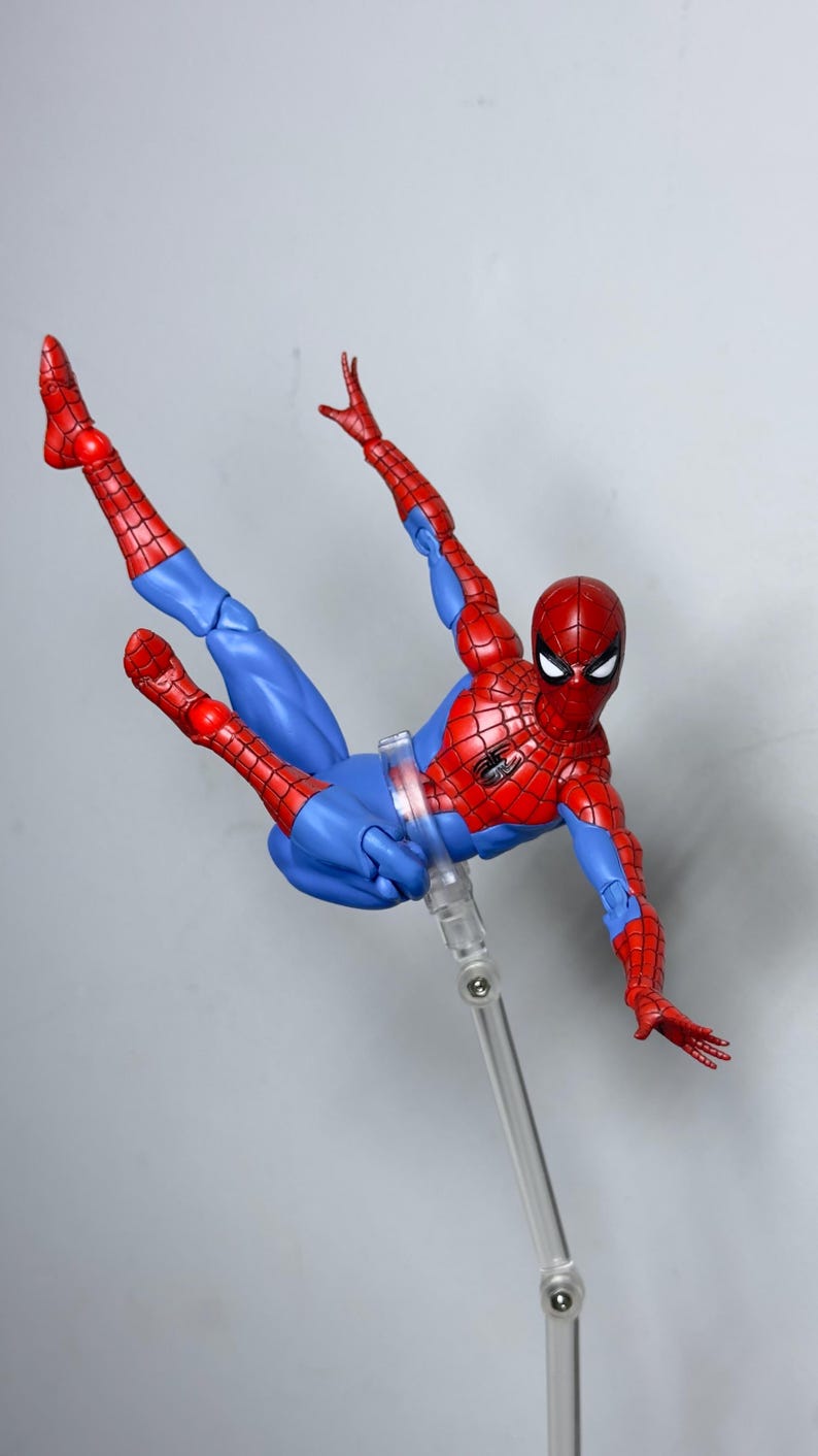 Puede incluir: Figura de acci&oacute;n de Spider-Man en una pose din&aacute;mica, con un traje rojo y azul. La figura est&aacute; suspendida en el aire, mostrando sus extremidades articuladas y su ic&oacute;nico dise&ntilde;o de telara&ntilde;a. La figura mide aproximadamente 15 cm de altura.