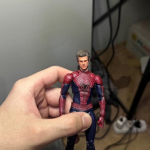 Może przedstawiać: Figurka Spider-Mana w klasycznym czerwono-niebieskim kostiumie. Figurka ma szczeg&oacute;łowy design z wzorem pajęczyny na czerwonych elementach. Figurka ma około 15 cm wysokości.
