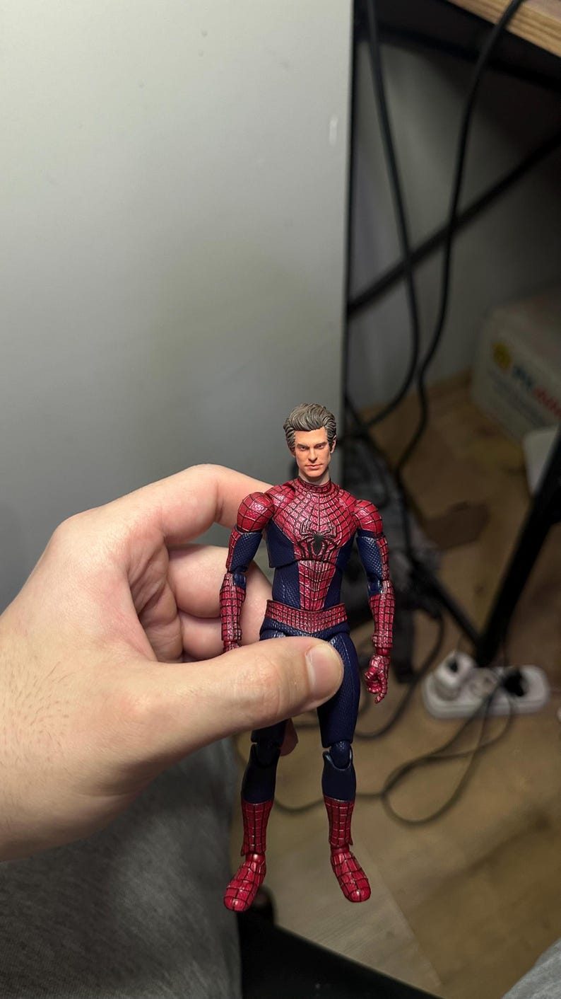 Może przedstawiać: Figurka Spider-Mana w klasycznym czerwono-niebieskim kostiumie. Figurka ma szczeg&oacute;łowy design z wzorem pajęczyny na czerwonych elementach. Figurka ma około 15 cm wysokości.