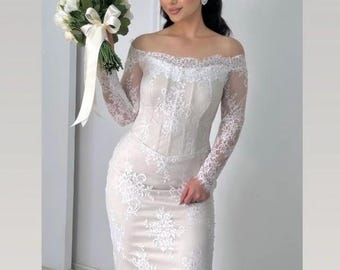 May include: A white off-the-shoulder wedding dress with long lace sleeves and a fitted bodice. The dress features intricate floral lace detailing and a mermaid silhouette. The bride is holding a bouquet of white flowers with a white ribbon.