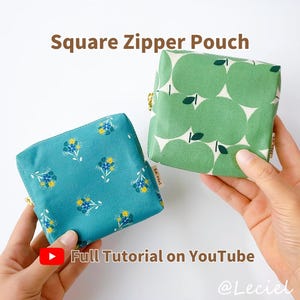 May include: Two square zipper pouches. One is teal with a floral pattern, the other is green with an apple design. Both have gold zippers. The text "Square Zipper Pouch" and "Full Tutorial on YouTube" are visible.