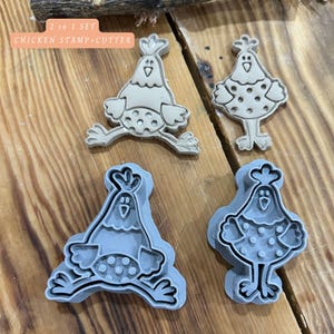 Könnte beinhalten: Ein Set aus vier Hühner-Ausstechern und Stempeln. Zwei sind die Stempelversionen und zwei die Ausstecher-Versionen. Der Text "2 in 1 SET CHICKEN STAMP+CUTTER" ist zu sehen. Die Werkzeuge sind hellgrau und beige.