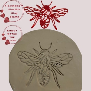 May include: A red bee-shaped FlexStamp with a matching impression in clay. The stamp is above the clay impression. Text on the left reads "FlexStamp Flexible Clay Stamp" and "Kindly Watch The Video".