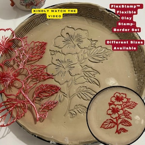 May include: A beige clay stamp with a floral design, featuring a large embossed flower and leaf pattern. A red floral stencil and a smaller stamped image are also visible. Text on the image reads "FlexStamp Flexible Clay Stamp-Border Set".