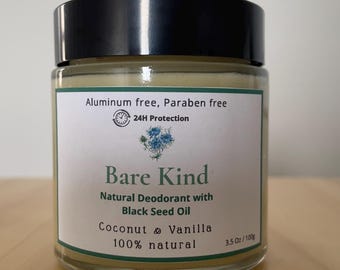 Puede incluir: Un tarro de cristal de desodorante natural Bare Kind con tapa negra. La etiqueta dice "Sin aluminio, sin parabenos" y "Coco y vainilla". El tarro contiene 100g de producto.