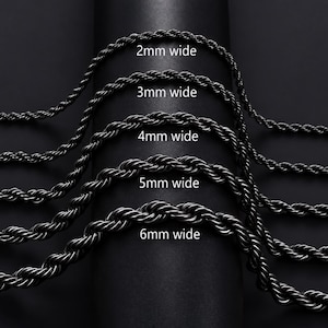 Puede incluir: Cinco cadenas de cuerda negras dispuestas en paralelo, etiquetadas con sus respectivos anchos: 2mm wide, 3mm wide, 4mm wide, 5mm wide y 6mm wide. Cada cadena presenta un diseño trenzado y texturizado, mostrando el grosor de los eslabones.