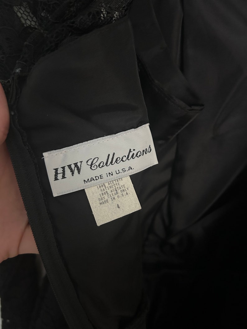 Pode incluir: Uma etiqueta branca com texto preto que diz "HW Collections Made in U.S.A. 100% Acetate Satinest 100% Acetate Dry Clean Only Made in U.S.A. 4"