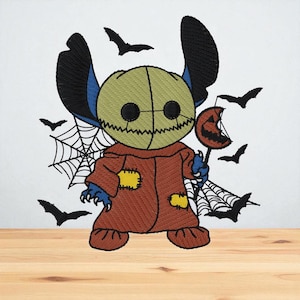 May include: Embroidered Halloween design featuring a character dressed as Sam from Trick 'r Treat. The character is wearing a brown costume with yellow patches, holding a pumpkin lollipop, surrounded by bats and spiderwebs. The character has blue skin and large black ears.