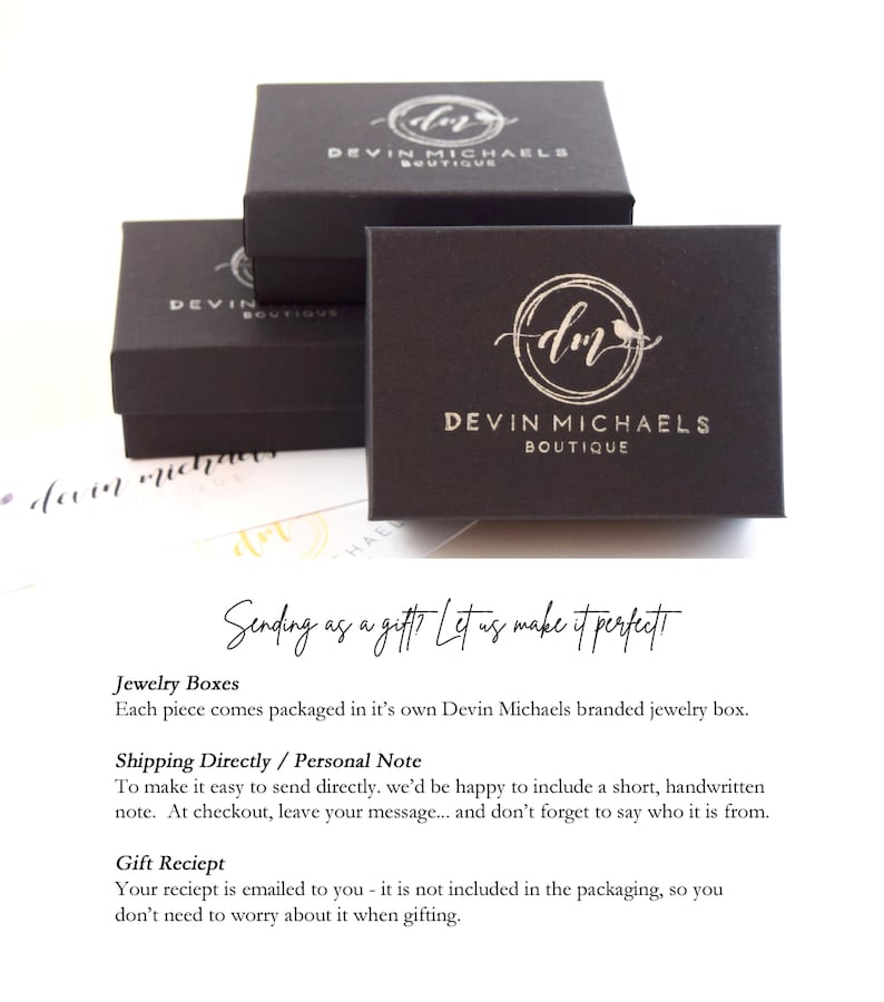 May include: Black jewelry boxes with a silver logo that says "Devin Michaels Boutique" and a stylized "dm" with a bird. The text "Sending as a gift? Let us make it perfect" is written in white on a black background.