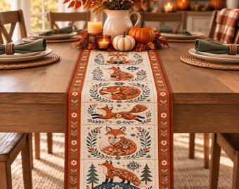 May include: A rectangular fabric table runner featuring a repeating pattern of foxes in various poses, surrounded by floral and botanical motifs in shades of orange, brown, and blue. The runner has a wide burnt orange border with white flower accents.