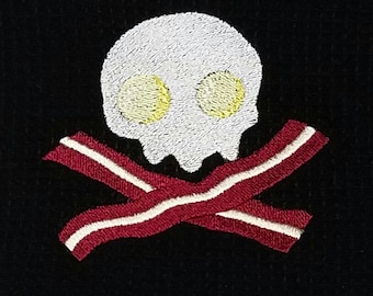 Paño de cocina con forma de calavera, tocino y huevos