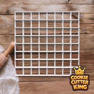 May include: A white square grid cookie cutter with multiple small square cutouts. The cutter is on a wooden surface with a rolling pin and the "Cookie Cutter King" logo in the corner.