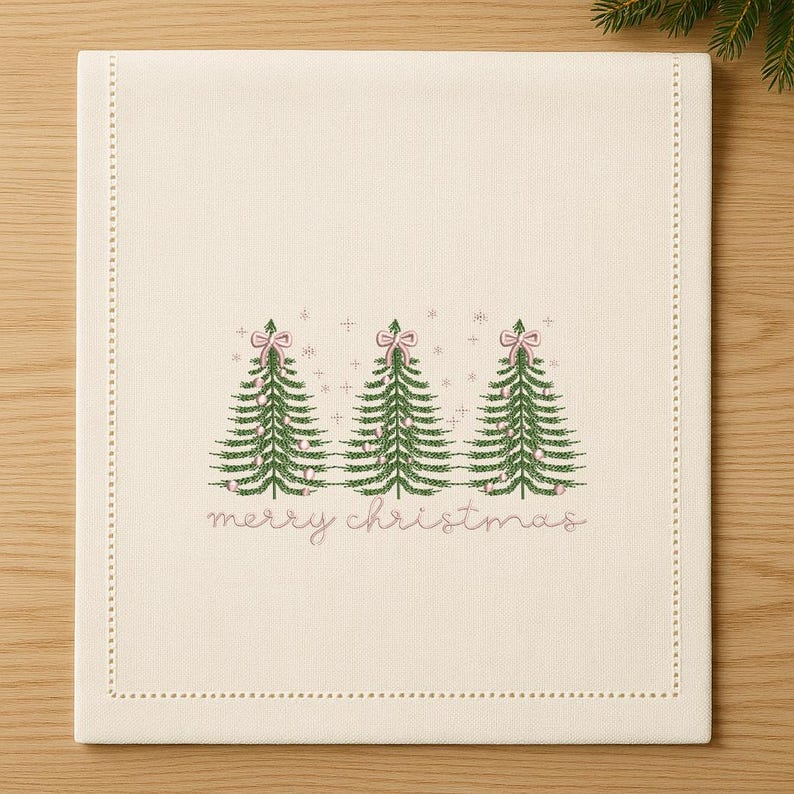 May include: Cream-colored Christmas table runner with embroidered green Christmas trees, pink bows, and the words "merry christmas" in pink. The runner has a dotted border.