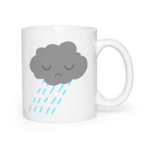 May include: White ceramic mug with a gray cloud with a sad face and blue raindrops. The cloud is raining.