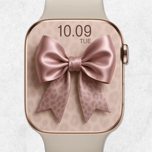 May include: A beige smartwatch with a rose gold case and a blush pink bow design on the screen. The screen displays the date and day of the week. The bow has a leopard print pattern on the tails.