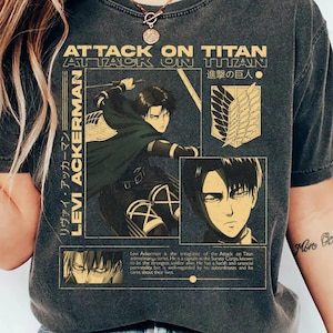 Könnte beinhalten: Ein anthrazitfarbenes Kurzarm-T-Shirt mit einem Grafikdruck der Figur Levi Ackerman aus Attack on Titan. Das Design enthält den Text Attack on Titan, Levi Ackerman, japanische Schriftzeichen sowie das Emblem des Aufklärungstrupps.