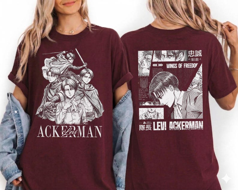 May include: Maroon t-shirt featuring a manga-style illustration of characters with swords and capes. The front of the shirt displays the word "ACKERMAN" in white. The back of the shirt has a manga panel with the text "WINGS OF FREEDOM" and "LEVI ACKERMAN".