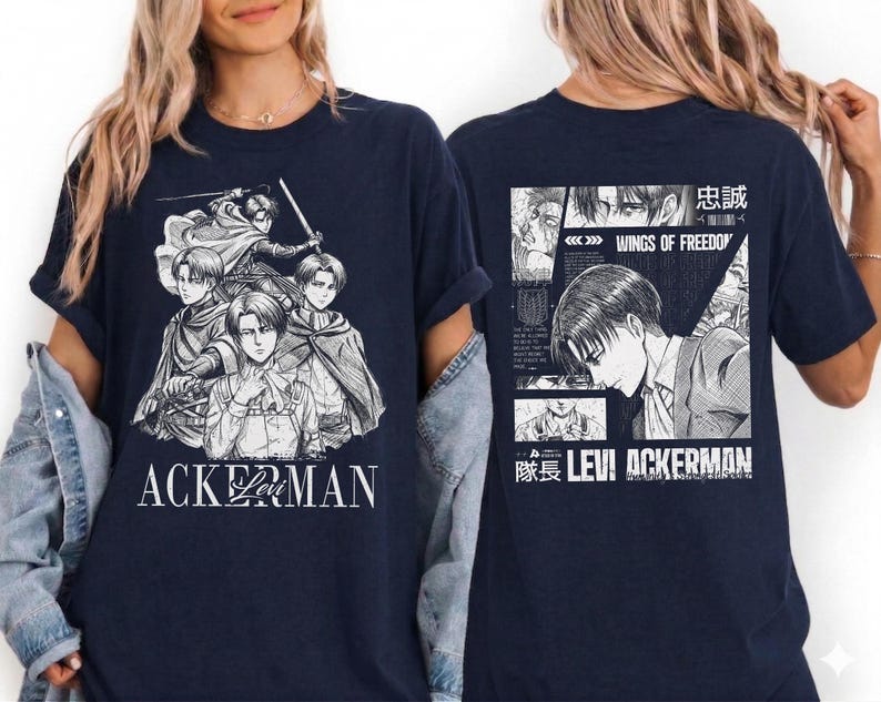 May include: Navy blue t-shirt featuring a black and white graphic of anime characters. The front of the shirt displays a group of characters with the text "ACKERMAN". The back of the shirt has a manga-style design with the text "WINGS OF FREEDOM" and "LEVI ACKERMAN".