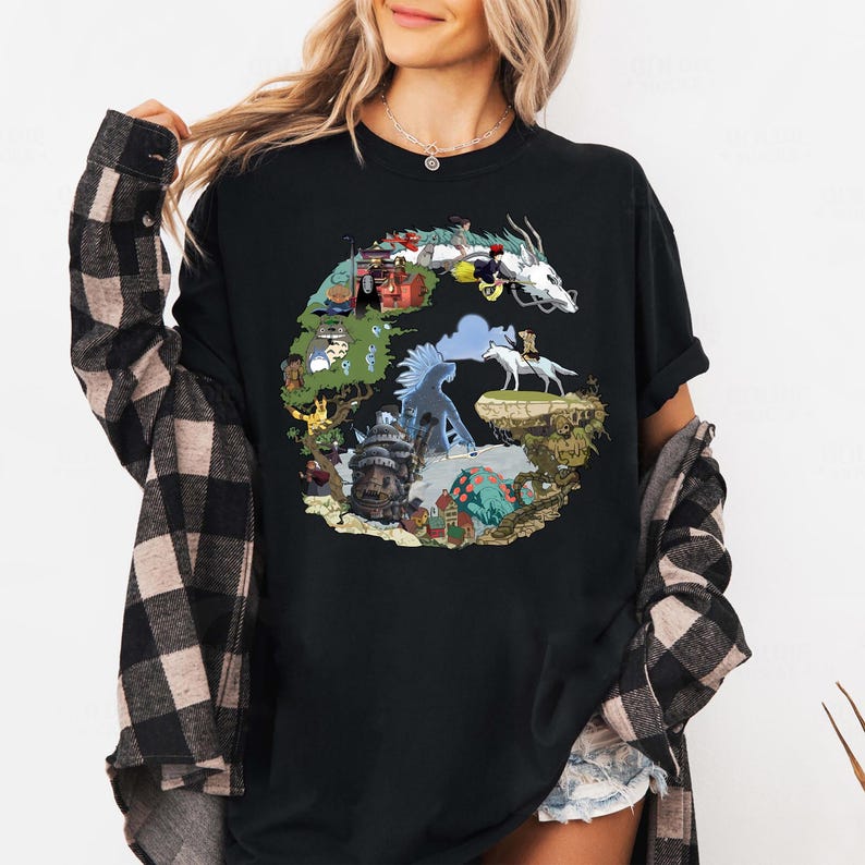 May include: Black t-shirt featuring a colorful graphic design of a dragon and various animated characters. The design includes a white dragon, figures on horseback, and architectural elements. The shirt is made of a soft material.