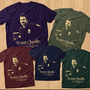 May include: Five t-shirts in various colors: purple, olive green, burgundy, navy blue, and dark green. Each shirt features a graphic of a man and the text "Team Charlie the twilight saga."