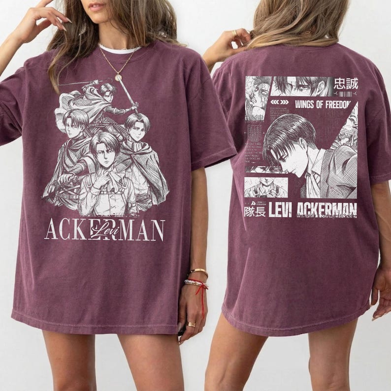 May include: Maroon t-shirt featuring a manga-style illustration of characters with the text "ACKERMAN" on the front. The back of the shirt displays a collage of images and text, including "WINGS OF FREEDOM" and "LEVI ACKERMAN".