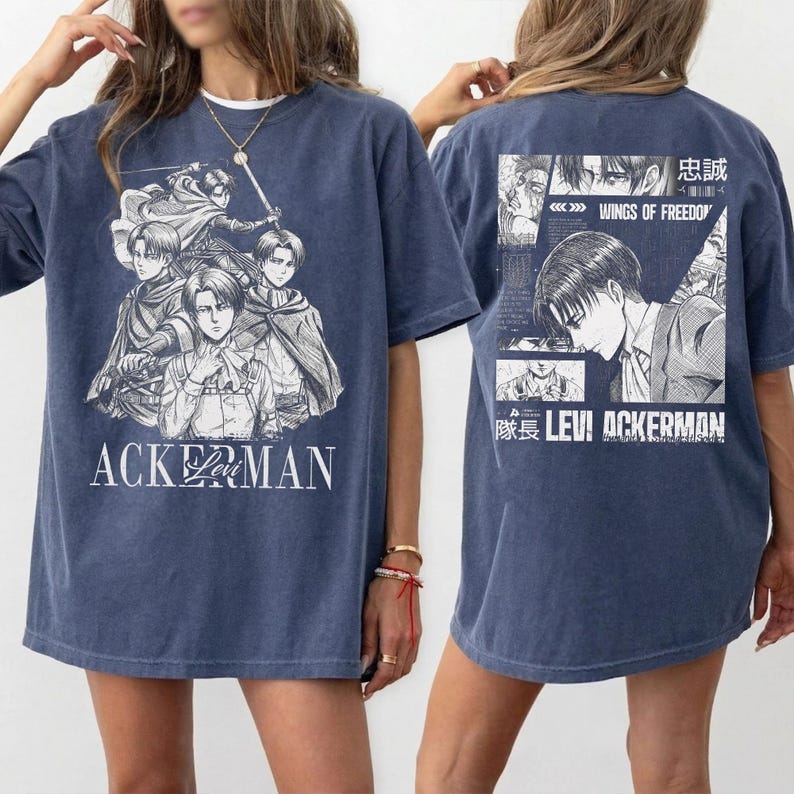 May include: A blue t-shirt featuring a graphic of anime characters with the text "ACKERMAN" on the front. The back of the shirt displays additional anime graphics and the text "WINGS OF FREEDOM" and "LEVI ACKERMAN".