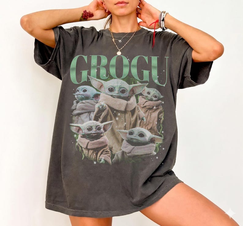 Puede incluir: Camiseta gris oscuro con un gr&aacute;fico de Grogu, tambi&eacute;n conocido como Baby Yoda, de The Mandalorian. La palabra "GROGU" est&aacute; impresa en verde encima de la imagen de Grogu. La camiseta tiene un aspecto vintage y desgastado.