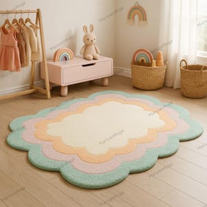 May include: A multi-coloured cloud-shaped rug in pastel shades of green, pink, peach, and cream. The rug has a soft, textured finish and is placed on a light wooden floor. The rug's design creates a playful and inviting atmosphere, suitable for a child's room.