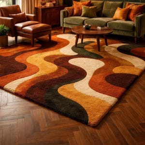 Op de afbeelding: Een rechthoekig vloerkleed met een golvend, meerkleurig patroon in tinten donkerbruin, gebrand oranje, mosterdgeel en crème. Het kleed heeft een dikke, getextureerde pool en bedekt een groot deel van de donkerhouten visgraatvloer.