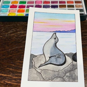 Cartão postal "Selo pintado à mão ao pôr do sol"