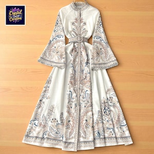 May include: A white dress with a paisley pattern in shades of blue, brown, and beige. The dress features long, flared sleeves, a high collar, and a matching belt with a circular buckle. The dress has the text "Crystal Luxe Creation" in the upper left corner.