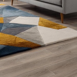 Artisan rug with angular design, handmade using soft wool and sustainable materials for stylish British homes. Modern geometric wool rug blending grey, blue, and mustard tones, perfect for minimalist interiors across the UK and Europe.