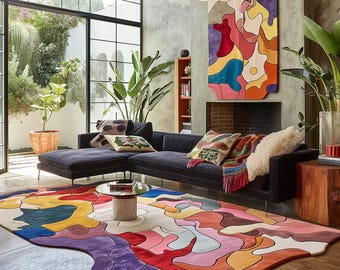 May include: A modern living room with a dark blue sectional sofa, colorful abstract rug, and a large abstract wall hanging. The room features large windows, plants, and a small coffee table.