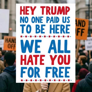 May include: A protest sign with the message "HEY TRUMP NO ONE PAID US TO BE HERE WE ALL HATE YOU FOR FREE" in red and blue text. The sign is held up in a crowd of people.