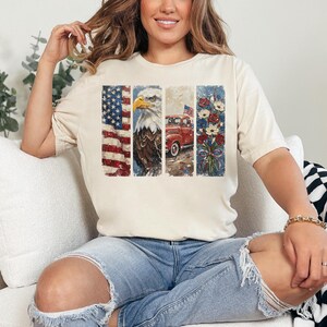 Puede incluir: Una camiseta color crema con un dise&ntilde;o patri&oacute;tico. El dise&ntilde;o incluye la bandera estadounidense, un &aacute;guila, una camioneta roja con una bandera y un ramo de flores. La camiseta la lleva una persona.