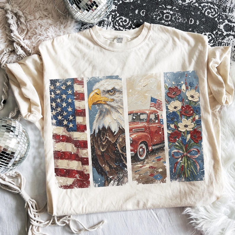 K&ouml;nnte beinhalten: Cremefarbenes T-Shirt mit patriotischem Design. Die Grafik zeigt die amerikanische Flagge, einen Wei&szlig;kopfseeadler, einen roten Oldtimer-Truck mit Flagge und einen Strau&szlig; roter, wei&szlig;er und blauer Blumen. Das Shirt besteht aus einem weichen, bequemen Material.