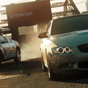 May include: A light-colored sports car speeds down a road, with a police car in pursuit. The image has a gritty, action-packed feel, with the word "Criterion" visible on a sign in the background.