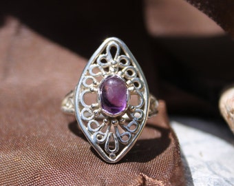 May include: A silver ring with an intricate filigree design and a purple amethyst gemstone.