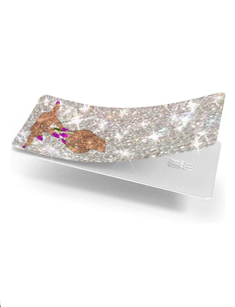 Może przedstawiać: Srebrna, brokatowa tacka do zwijania z ilustracją dłoni z fioletowymi paznokciami. Taca jest zakrzywiona i ma białą podstawę z trzema wytłoczonymi liniami.