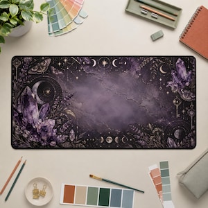 Può includere: Un tappetino da scrivania rettangolare con uno sfondo marmorizzato viola scuro e nero, caratterizzato da illustrazioni di grappoli di cristalli di ametista, lune crescenti, stelle, falene, chiavi e rametti di lavanda lungo i bordi.