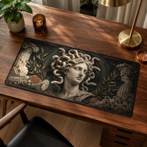 Puede incluir: Una alfombrilla de escritorio rectangular que presenta un busto de piedra de Medusa con serpientes por cabello, rodeado de elementos arquitectónicos griegos clásicos, incluyendo columnas de mármol y ramas de laurel en tonos oscuros.