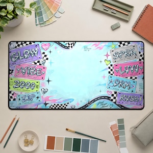 May include: A rectangular desk mat featuring a light blue background with a Y2K-inspired graphic design. It displays various license plate-style graphics with text including GLOW, VIBE, 2000, ZIP, SPRK, LUVU, DRM, and RUSH, accented by hearts, stars, and checkered patterns.