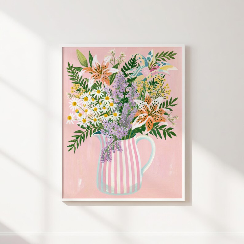 Pu&ograve; includere: Una stampa artistica incorniciata con una colorata composizione floreale in una brocca a righe. Il bouquet include gigli, margherite e lavanda, su uno sfondo rosa tenue. La brocca ha strisce rosa e bianche.