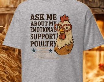 May include: A gray t-shirt with the text "ASK ME ABOUT MY EMOTIONAL SUPPORT POULTRY" and a cartoon chicken wearing heart-shaped glasses. Two blue stars are below the text. The chicken has a red comb and wattle.
